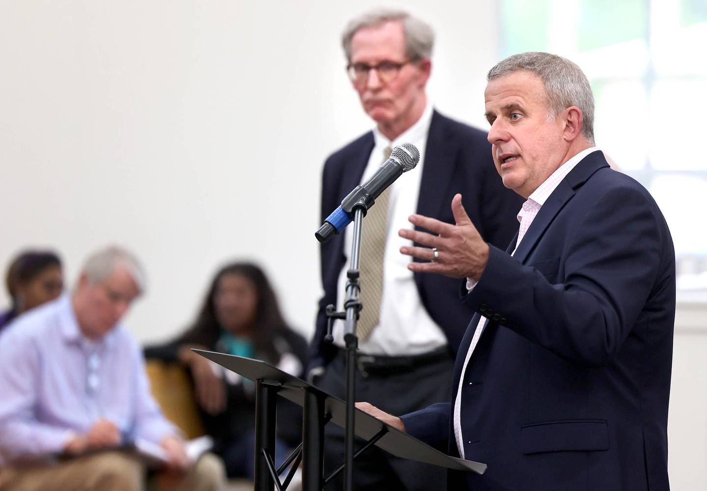 DeKalb Mayor Cohen Barnes speaks as City Manager Bill Nicklas looks on during the informational meeting Thursday, May 18, 2023, at New Hope Missionary Baptist Church in DeKalb. The meeting centered on the the proposed plans for the vacant lot on the corner of Blackhawk Road and Hillcrest Drive in DeKalb.