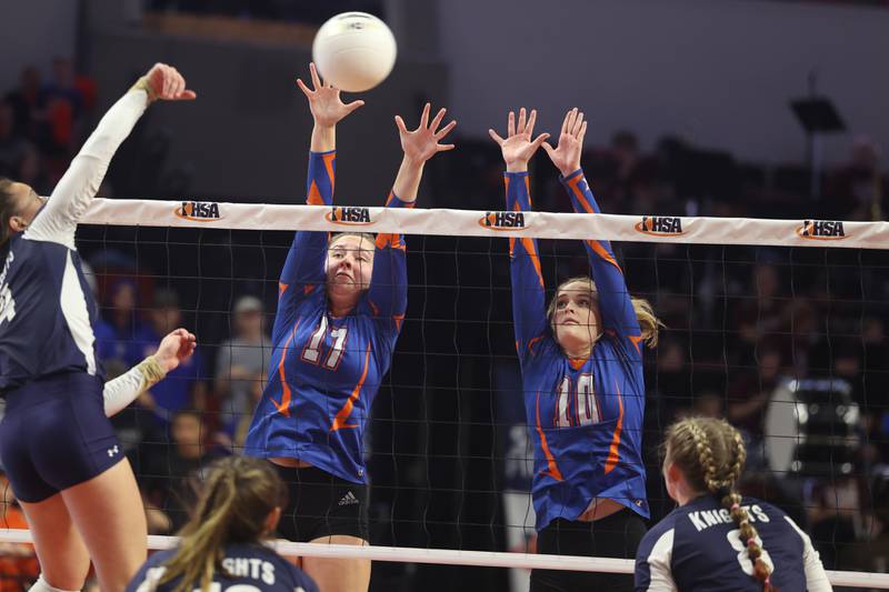 Genoa-Kingston’s Lily Mueller (17) and Rylie Stoffregen (10) go for the block against  IC Catholic in the Class 2A championship match on Saturday in Normal.