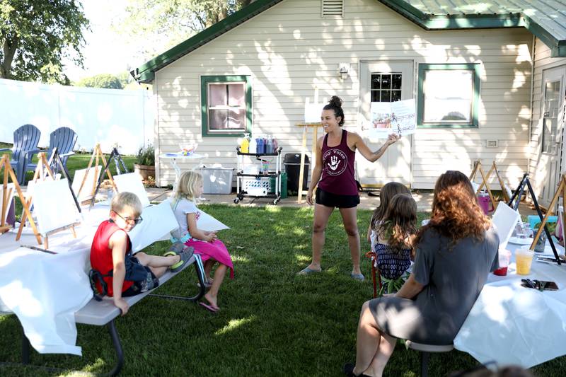 Elizabeth Nielsen, owner of the Little Cottage on the Farm in Kaneville, reads the children’s book she wrote, “Udder Chaos” during a painting class at the farm on Thursday, July 27, 2023.