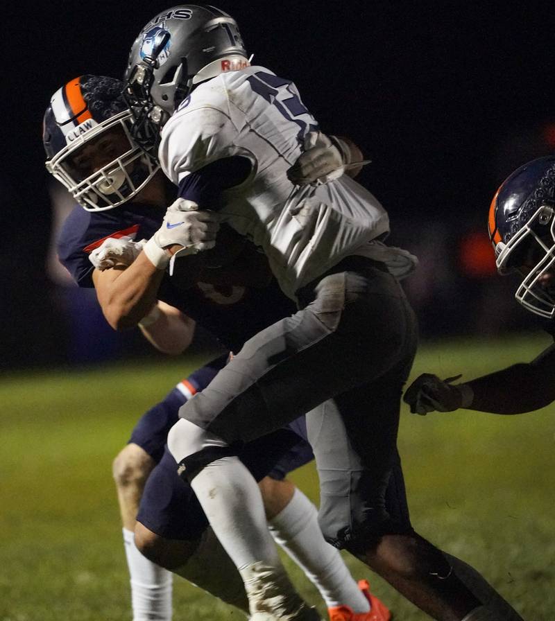 Oswego’s Michael Claycombe (6) tackles Oswego East's Jasiah Watson (13) during a football game at Oswego High School on Friday, Oct. 20, 2023.