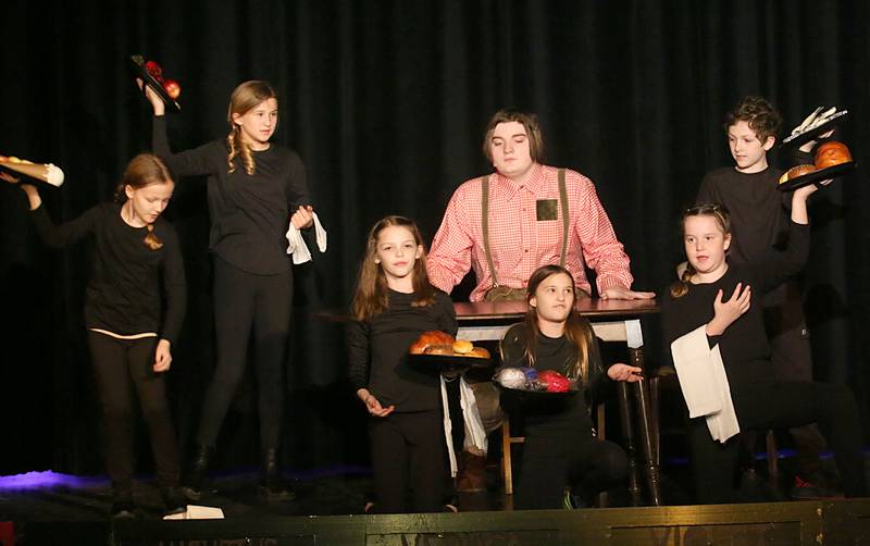 Augustus Gloop, played by Garret Luke (middle) acts out a scene with the older kid chorus members Aubrey Zborowski, Avery Lenkaitis, Savannah Grasser, Guiliana Cimei, Murphy Hopkins and Caius Luncsford during a performance of Willy Wonka on Thursday, March 16, 2023 at Putnam County High School.