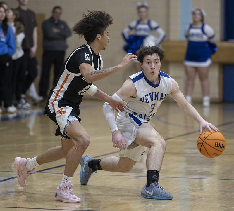 Newman’s Garret Matznick handles the ball against Kewanee’s Catrelle Reed Friday, Jan. 10, 2025.