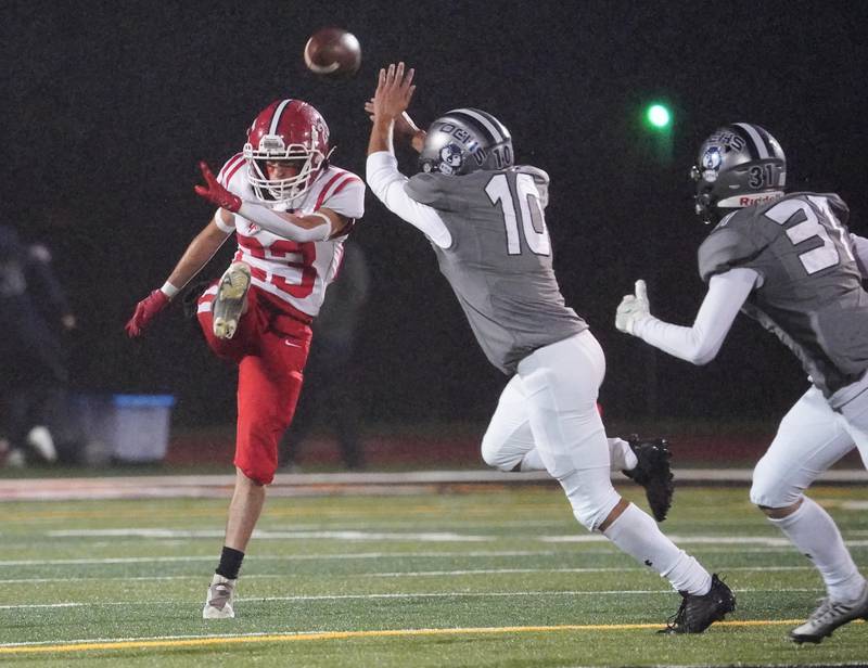 Yorkville's Dom Recchia (23) punts the ball over Oswego East's Tyler Stamatis (10) during a football game at Yorkville High School on Friday, Oct. 13, 2023.