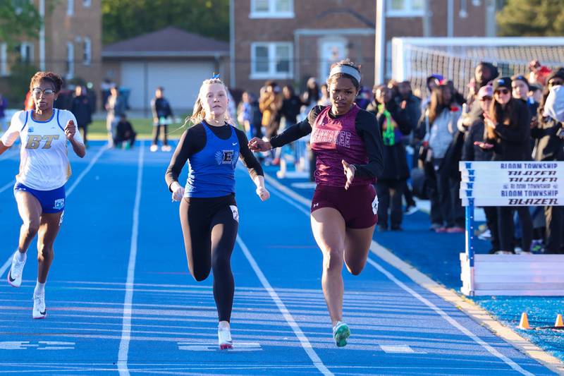 Kankakee's Trinity Noble, right, and Lincoln-Way East's Grace Murphy stride over the finish line in the 100-meter dash to qualify for state by taking fourth and fifth overall during the IHSA Class 3A Chicago Heights Girls Track and Field Sectional at Bloom High School on Wednesday, May 13, 2026.