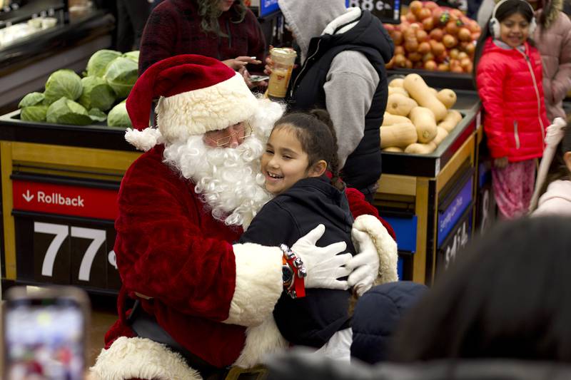 Joliet Police Officer Tony Lakota, dressed as Santa Claus, hugs one of the children participating in the 36th annual Santa's Cops event on Saturday, Dec. 6, 2025, at Walmart, 401 Illinois Route 59, in  Shorewood.