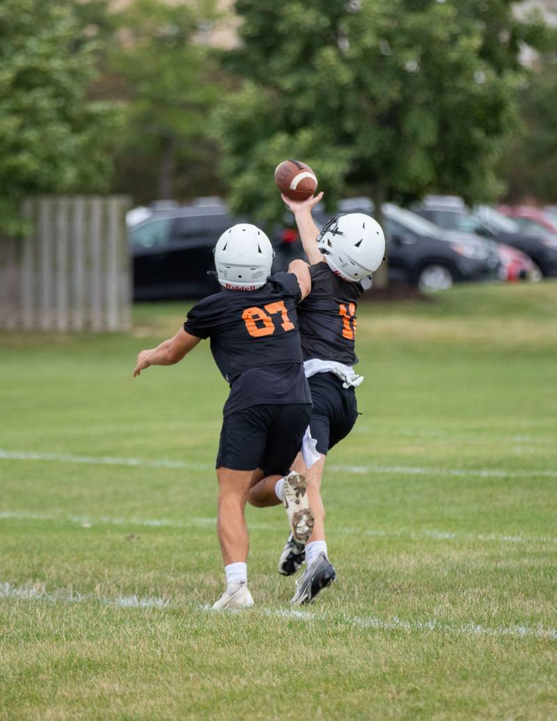 Quarterback Lane Robinson, left, and wide receiver Mason Tousignant run a drill during practice at St. Charles East on Monday, Aug. 8, 2022.