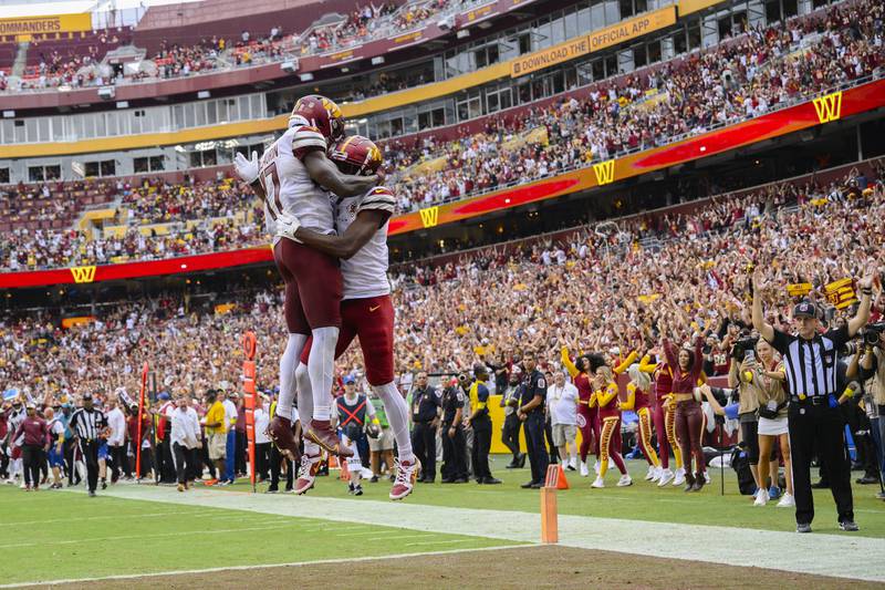 Washington Commanders wide receiver Jahan Dotson (1) celebrating his touchdown with teammate wide receiver Terry McLaurin (17) during the second half of an NFL football game against the Jacksonville Jaguars, Sunday, Sept. 11, 2022, in Landover, Md. Washington won 28-22. (AP Photo/Nick Wass)
