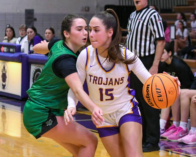 Downers Grove North's Adysen Fanta (15) drives around York's Ellie Kehoe (12) during the game on Tuesday Dec. 3, 2024, held at Downers Grove North High School.