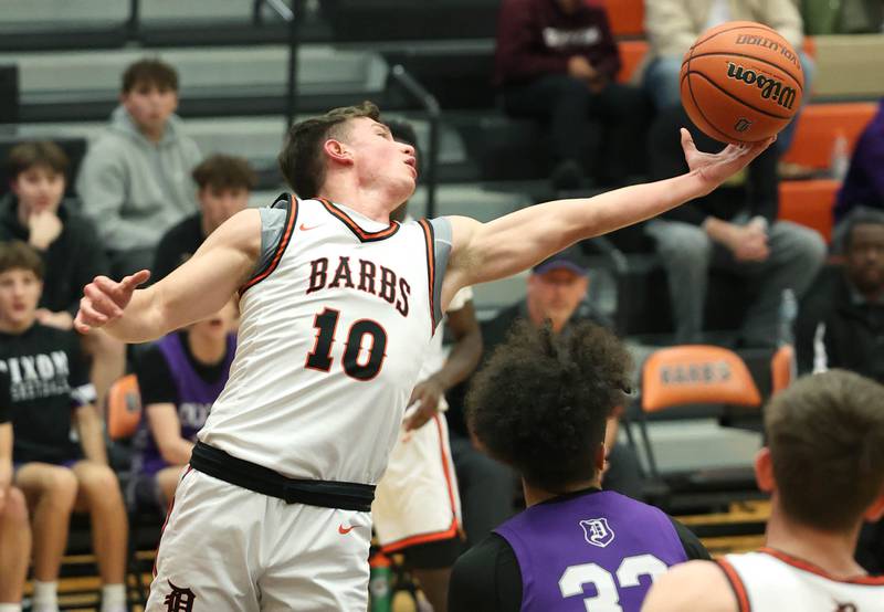 DeKalb’s Eric Rosenow grabs a rebound over Dixon’s Darius Harrington during their game Tuesday, Dec. 12, 2023, at DeKalb High School.