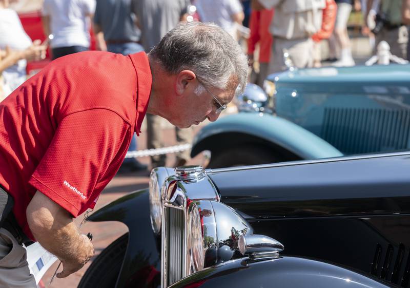 "You're looking for how pristine the paint is." Says show judge James Dorfman, of Lake Zurich, as he carefully inspects a 1945 MG TC Roadster owned by Tom Wilson of Zionsville, Ind., during  the 2024 Geneva Concours d'Elegance on Sunday, August 25, 2024 in downtown Geneva. Car enthusiasts gathered along Third Street to display classic, antique and modern automobiles.