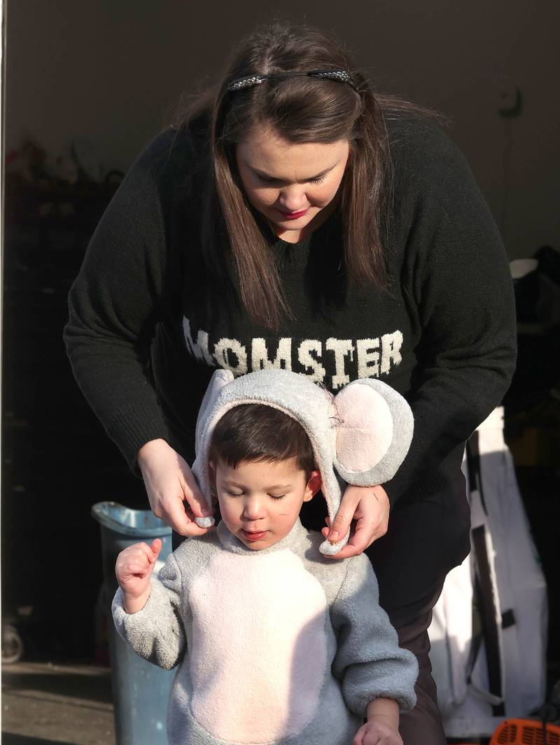 Stephanie Murray, helps her son Wyatt, 2, get his hat on as they prepare to go trick-or-treat on Halloween, Friday, Oct. 31, 2025, in DeKalb.