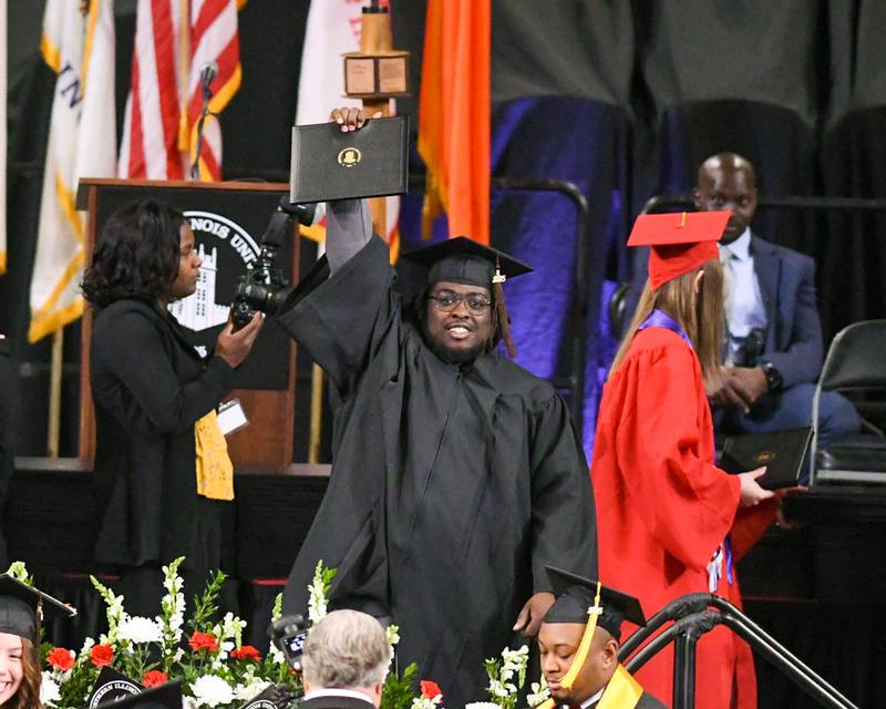 A Northern Illinois University graduate celebrates after receiving his diploma on Saturday, May 10, 2025, during the Class of 2025 Commencement ceremony held at the Convocation Center in DeKalb.