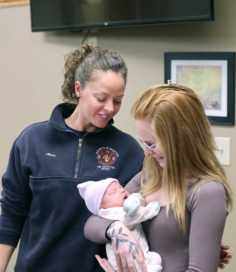 Genoa-Kingston firefighter paramedic Alicia Dimova smiles at a napping Eleanor Lee Altepeter-Knotts, and her mom Sammie Altepeter from Kingston Thursday, Nov. 2, 2023, as the baby and her family visit the Genoa-Kingston Fire Department in Genoa. Dimova and the rest of the ambulance crew delivered the baby in the ambulance along the side of the road Sept. 29 when they realized they weren’t going to make it to the hospital in time.