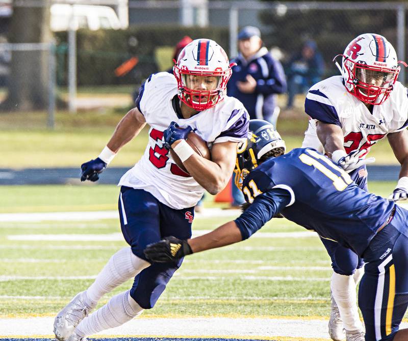 St. Rita's Kaleb Brown runs the ball while Sterling's Tyree Kelly attempts a tackle during the third quarter of the game. Brown put up 245 yards on 24 carries for a decisive 32-0 victory over the Warriors.