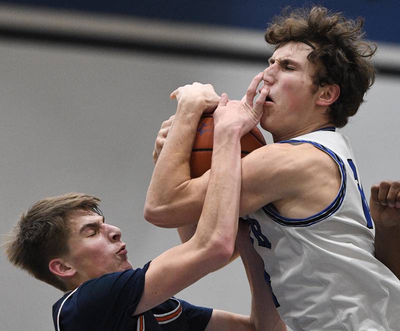 Despite getting poked in the nose, St. Charles North’s Colin Ross gets a rebound against Naperville North’s Grant Montanari in a boys basketball game in St. Charles on Wednesday, January 18, 2023.