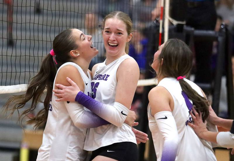 Hampshire’s Kylie Lambert, left, and Anna Schiltz celebrate a three-set win over the host Red Raiders in girls varsity volleyball at Huntley High School on Thursday, October 23, 2025.