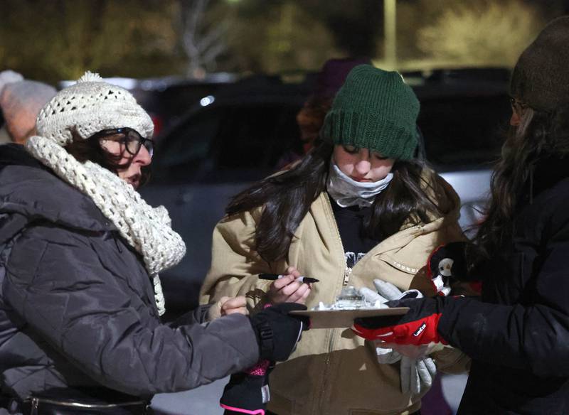 Anna Wilhelmi, DeKalb County Democratic Party chair, brings around a petition to be signed Monday, Jan. 26, 2026, during a vigil outside the DeKalb County Legislative Center in Sycamore after second shooting death in Minnesota involving ICE officers.