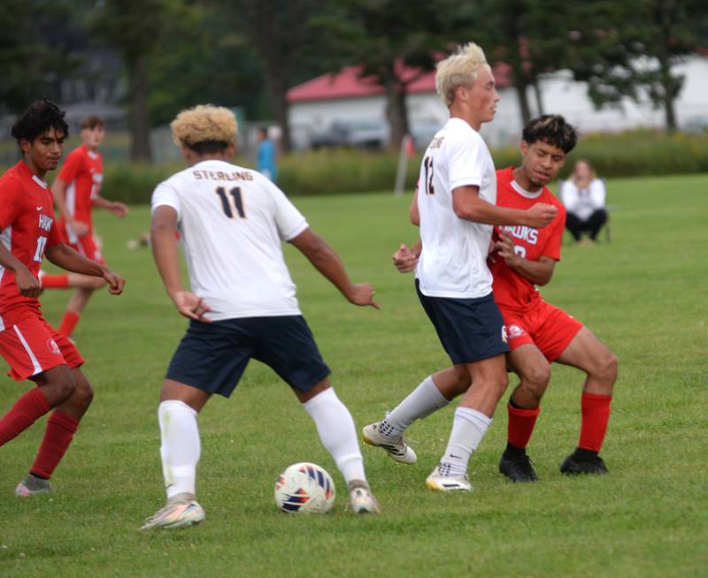 Sterling's Anthony Rosas (11) plays the ball as his teammate Ian Hilty (12) blocks Oregon's Steven Guardado (25) on Friday, Aug. 29, 2025 at the Oregon-Stillman Valley Varsity Soccer Tourney at Oregon Park West.