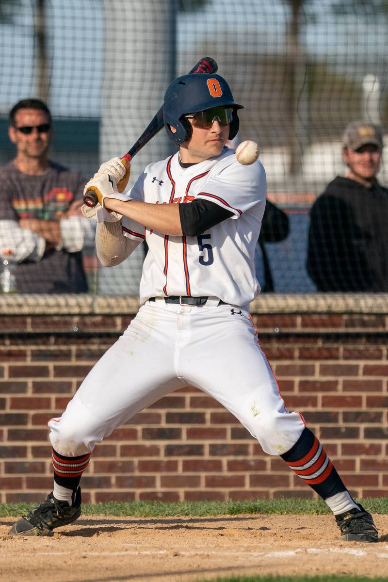 Oswego’s Ethan Valles (5) leans back to avoid an inside pitch during a baseball game against Minooka at Oswego High School on Tuesday, April 18, 2023.