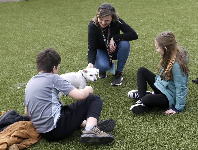 Jennifer Waldack, a fourth grade teacher at Mary Endres Elementary School, interacts with her students and a dog at Young At Heart on Tuesday, March 21, 2023, during a field trip to the senior animal rescue facility. Waldack helps run her school's Difference Makers program.