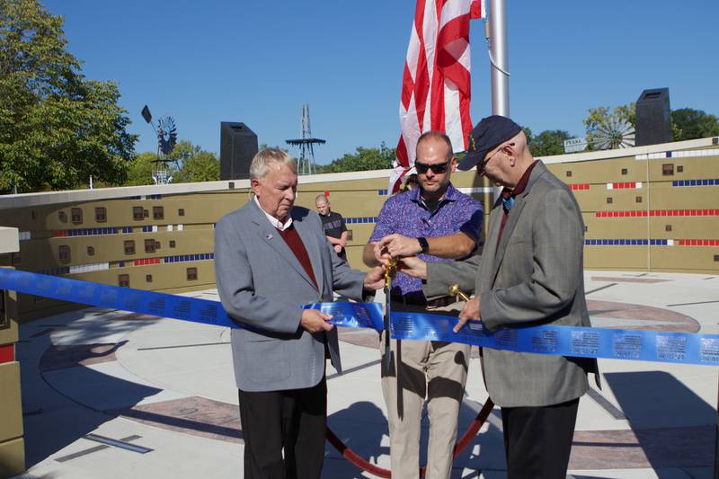 Mayor Jeffery Schielke (left) , Austin Dempsey (center) and National Medal of Honor Veteran Allen J Lynch (right) cut the ribbon during the Flag Day Monument opening ceremony's at Patriot's Park on Sunday, Oct 1,2023 in Batavia.