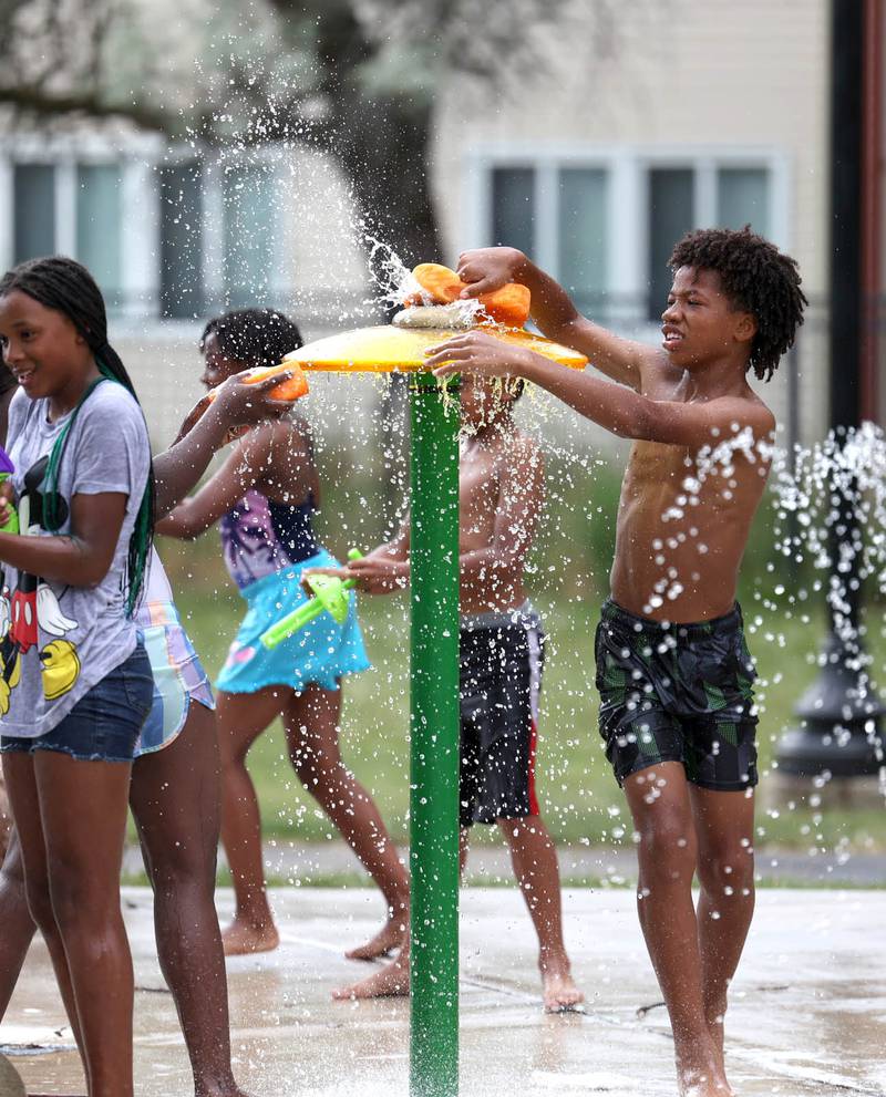Kids play on the splash pad Thursday, June 20, 2024, at the DeKalb Park District’s Welsh Park. High temperatures have been over 90 degrees every day this week making splash pads and pools very popular destinations.