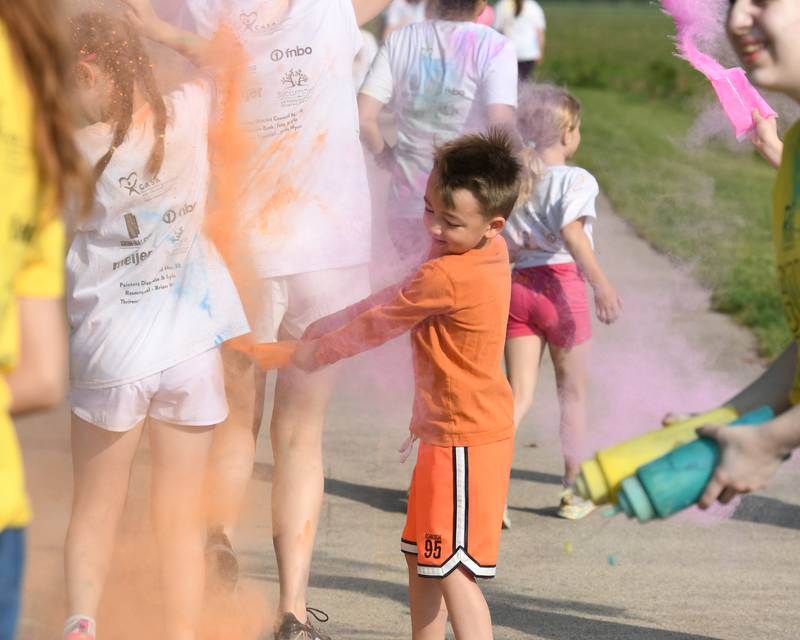 Jack Grashorn, 5, of Sycamore throws color powder on his sister on Saturday, June 7, 2025, during the CASA DeKalb County 5K Color Run held at the Sycamore Middle School.
