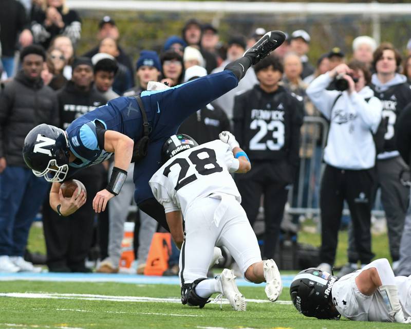 Nazareth Academy's Jackson Failla (2) gains some yards before being tripped up by Fenwick's Aiden Williams (28) during the 6A semifinals game on Saturday Nov. 22, 2025, held at Nazareth Academy High School in La Grange Park.
