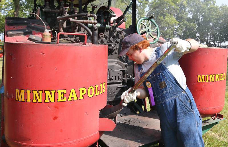 Danny Cork, from Burlington, gets coal to shovel into the broiler of his 1917 20 horsepower Minneapolis steam-powered tractor during the Sycamore Steam Show Thursday, Aug. 10, 2023, at Taylor Marshall Farm in Sycamore. The show runs from 7 a.m. to 5 p.m. through Sunday.