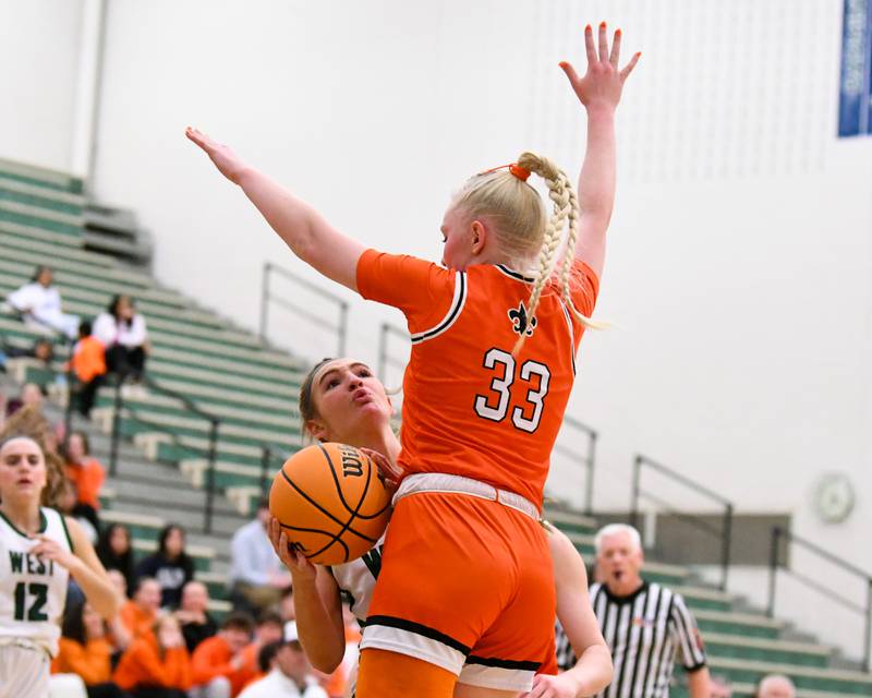 Glenbard West's Nina Hendricksen (1) gets fouled by St. Charles East's Addison Schilb (33) during the 4A Sectional championship game on Thursday Feb. 26, 2026, held at Bartlett High School.