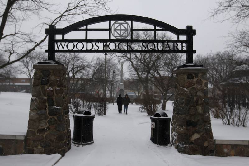 Men walks through the historic Woodstock Square on Thursday, Feb. 16, 2023, in Woodstock, after a winter storm moved through McHenry County creating hazardous driving conditions.