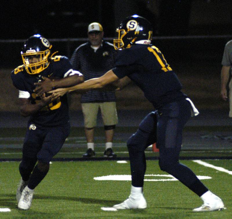 SHS Quarterback Brady Berlin hands to  Maurice De La Cruz in the first quarter.  The Galesburg Silver Streaks traveled to Sterling to take on the Warriors at Prescott Memorial Field at Roscoe Eades Stadium, September 26, 2025.