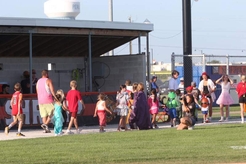 Kids dressed in Halloween theme costumes parade during the Illinois Valley Pistol Shrimp Halloween in July on Wednesday, July 23, 2025 at Schweickert Stadium in Peru. The event featured a Trick or Treat Scavenger Hunt presented by Peru Federal Savings Bank, Pregame Performance from the Hocus Pocus Hags and a kids costume parade.