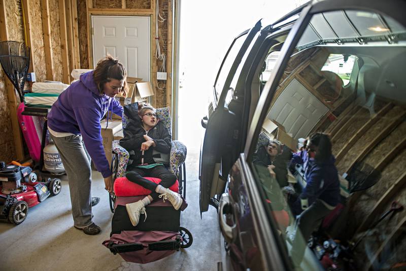Kelli Weidman places Addy into her wheelchair at their Dixon home. Addy was born with cerebeller hypoplasia, a neurological condition in which the cerebellum is smaller than usual or not fully developed. She was diagnosed at 7 months and has never been able to walk.