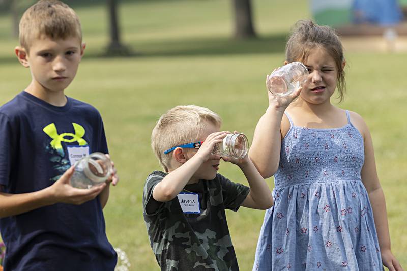 Woodlawn Arts Academy farm campers Connor (left), Javen and Jane look through the jars they will use to make flower bouquets Thursday, June 29, 2023. Campers have visited beef, dairy and a flower farm earlier this week. The Whiteside County Farm Bureau will be hosting camps in Morrison, Fulton and Erie in the coming weeks. A special camp from Cook County is also in the works.