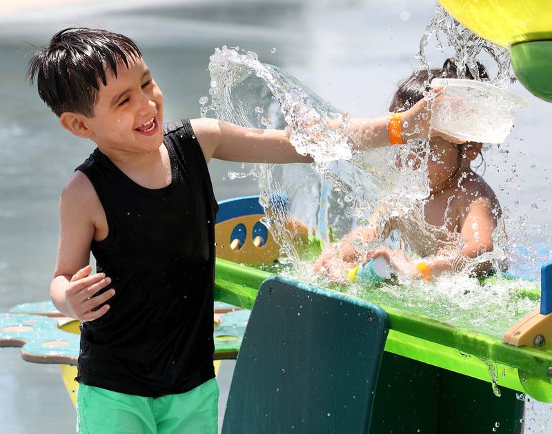 Luka Martinez, (left) 4, from DeKalb, is splashed by his brother Adrian, 2, Tuesday, June 24, 2025, on the Splash Fountain Splashpad at the Sycamore Park District Community Center.