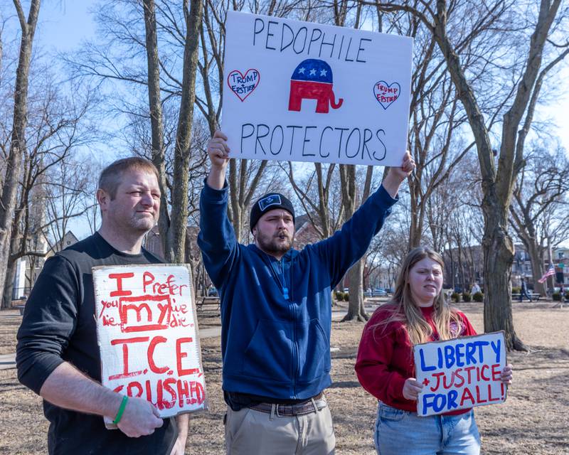 Protesters hold signs at the 'Pretti good time for a Protest' on Feb. 15, 2026 at Washington Square Park in Ottawa.
