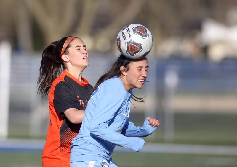 St. Charles East’s Tia Bernstein (left) and St. Charles North’s Bella Najera go after the ball during a Tri-Cities Night game at Geneva High School on Tuesday, April 26, 2022.