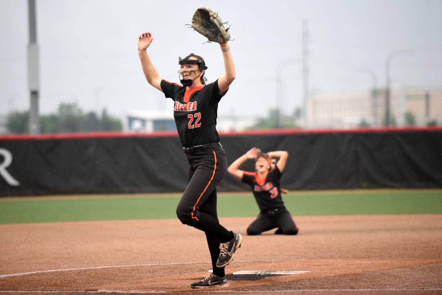 Beecher's Taylor Norkus lifts her arms in triumph as Ava Olson drops to her knees after Norkus recorded the final out of the Bobcats' 5-2 10-inning win over Carterville in the Class 2A State championship game at Peoria's Louisville Slugger Complex Saturday, June 7, 2025.