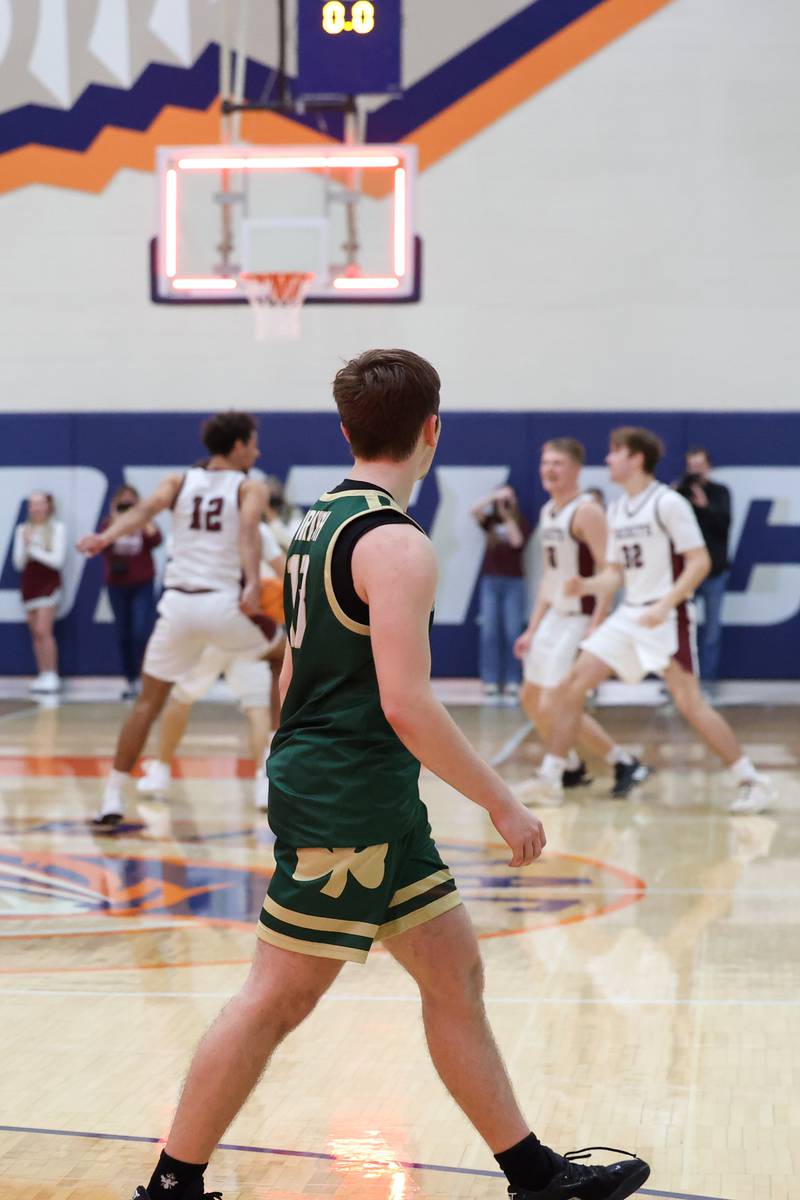 Bishop McNamara's Teddy Fogel leaves the court as Tolono Unity celebrates following the Fightin' Irish's 77-70 loss to Tolono Unity in the IHSA Class 2A Pontiac Supersectional on Monday, March 9, 2026.