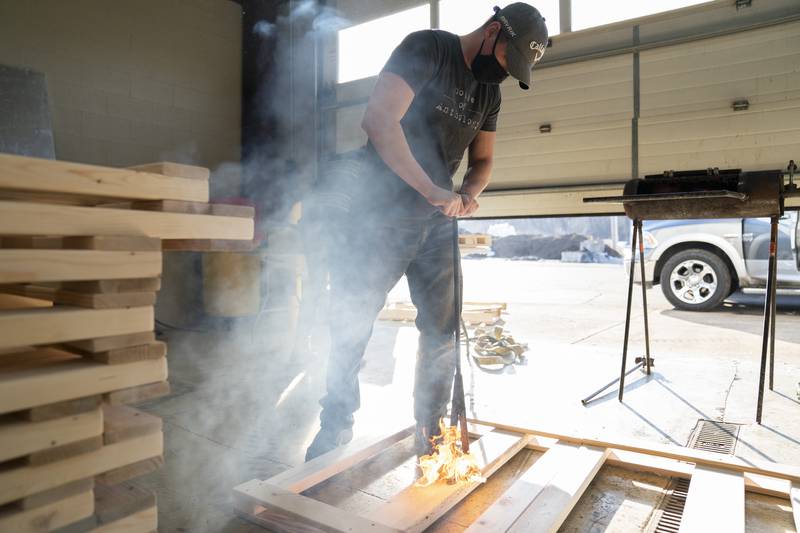 Bryan Bassett, of Spring Grove, uses a branding iron to mark part of a bed frame with the initials for Sleep in Heavenly Peace during a volunteer bed building event sponsored by the Sleep in Heavenly Peace organization on Saturday afternoon at the Algonquin Township Highway Department in Cary. The group builds and donates twin size beds to children and families in need around the area.  Ryan Rayburn for Shaw Local