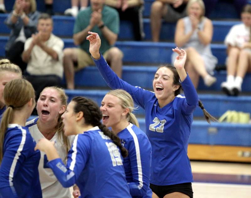 St. Charles North players, including Haley Burgdorf (far right), celebrate a point during a game at Rosary in Aurora on Monday, Aug. 21, 2023.