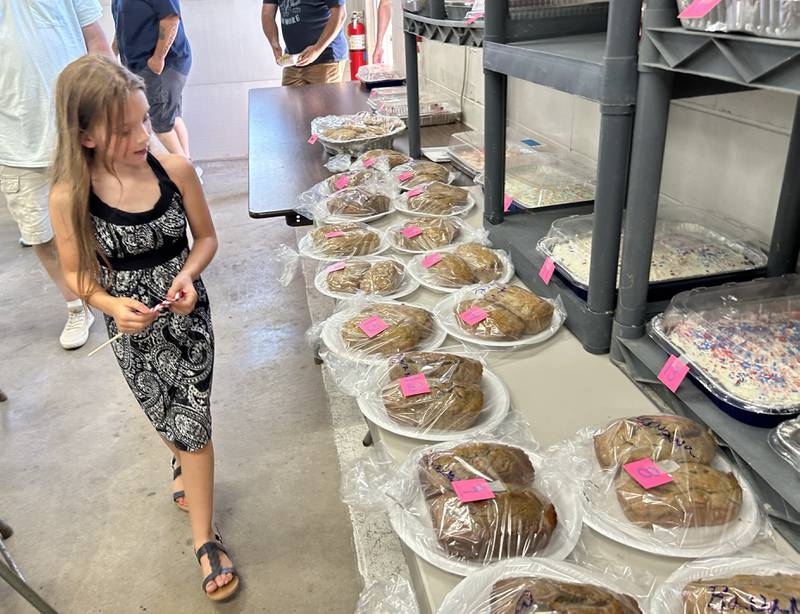 Gracie Martin, 8, of Prophetstown, decides which treat she won during the Hooppole Fun Day's Cake Walk held Saturday, June 28, 2025 in Hooppole.