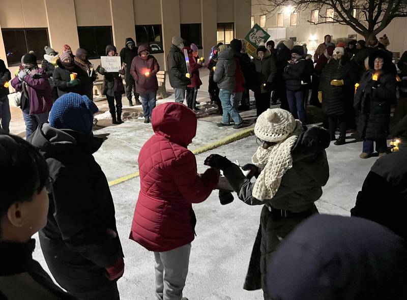 Attendees hold candles Monday, Jan. 26, 2026, during a vigil outside the DeKalb County Legislative Center in Sycamore after second shooting death in Minnesota involving ICE officers.