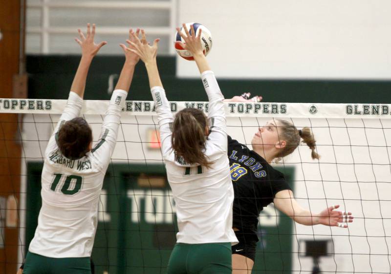 Lyons Township’s Alita Folkining (right) goes up for a kill during a game at Glenbard West in Glen Ellyn on Tuesday, Oct. 10, 2023.