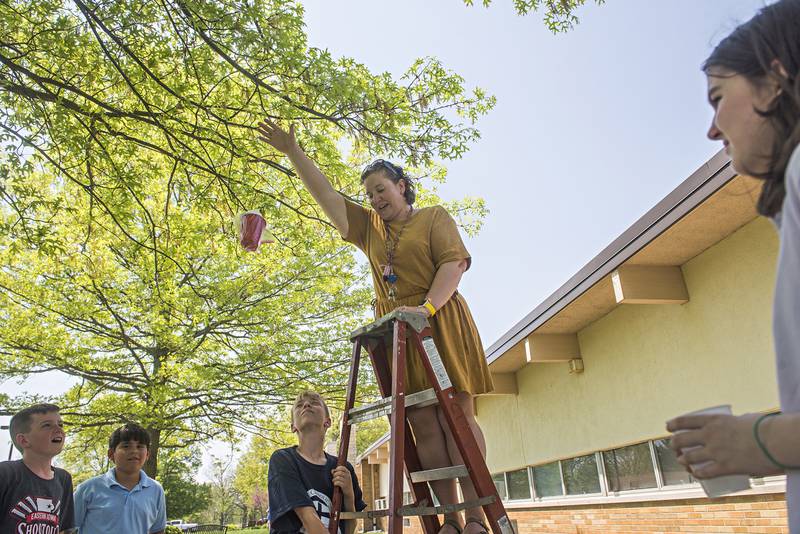 Third-grade teacher Audra Bates drops an protected egg Friday during a STREAM activity at St. Anne's School in Dixon. Groups of students were challenged to designing a way to protect a fragile payload when dropped from a ladder.