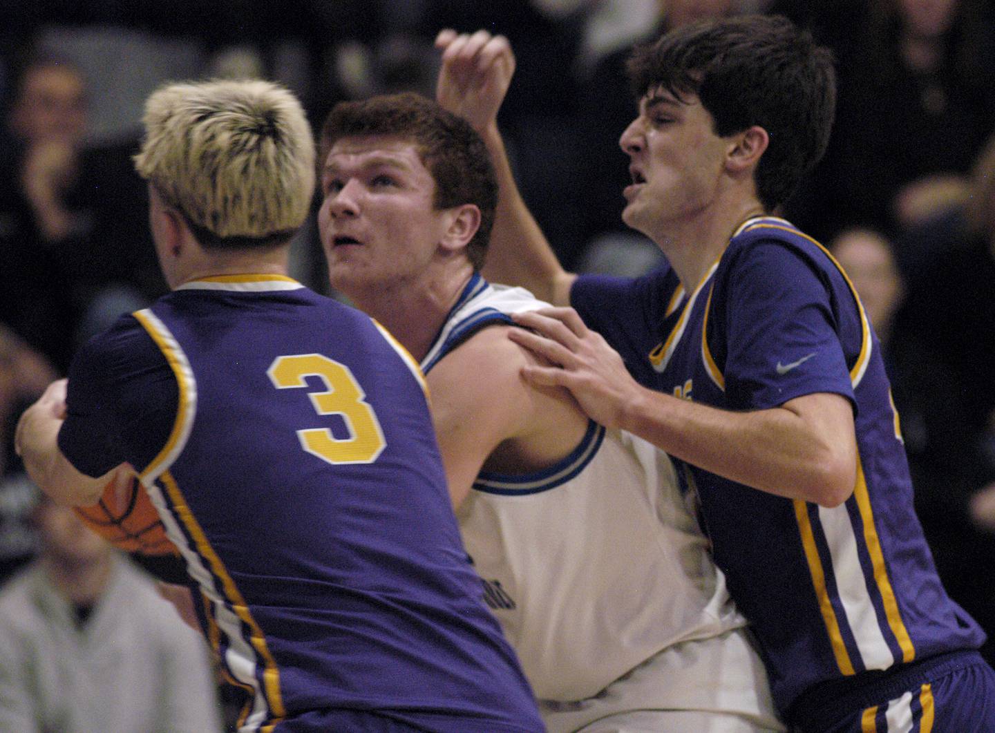 Newman's John Rowzee drives to the basket against a pair of Mendota defenders, including Alex Beetz (3). The Newman Comets defeated the Mendota Trojans 67-66 at Newman High School in Sterling. The game took place on Tuesday, January 13, 2025.