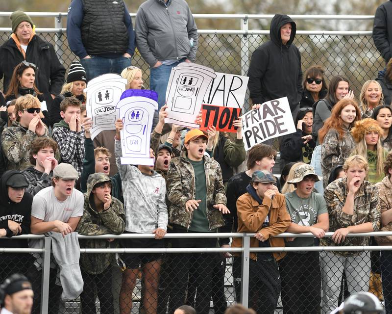 Fenwick fans hold up signs while playing defense on Saturday Nov. 9, 2024, during the second week of class 3A game while traveling to take on Downers Grove North High School.