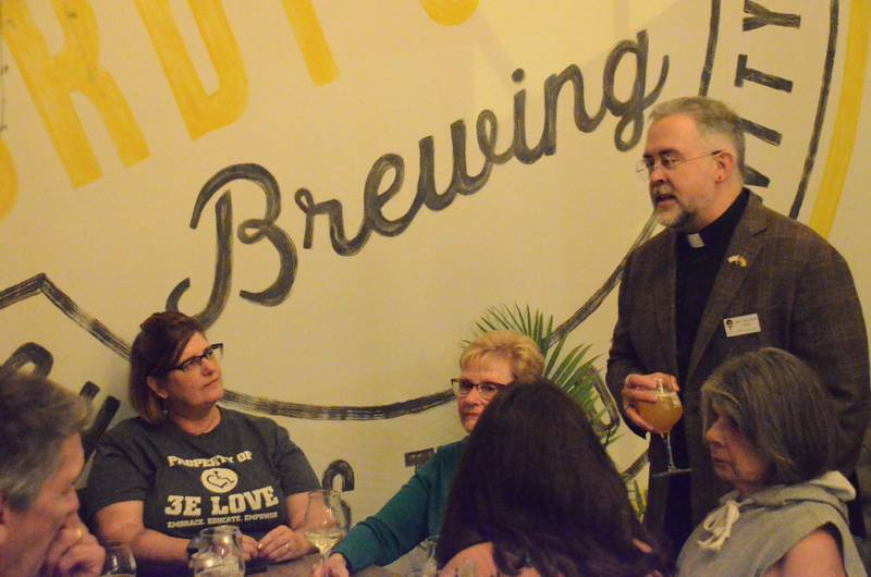 Rev. Scot Hull, right, Unitarian Universalist Society pastor, greets attendees at a Pub Theology discussion Sept. 28 at Sturdy Shelter Brewing in Batavia. (Al Benson photo)