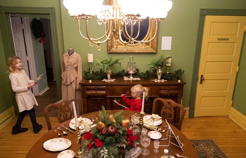 Lucy Ray (9), left, leads her sister Alex Ray (4) through the 1892 Blodgett House scavenger hunt during a Merry & Bright Victorian Christmas at the Downers Grove Museum on Saturday, Dec. 14, 2024.